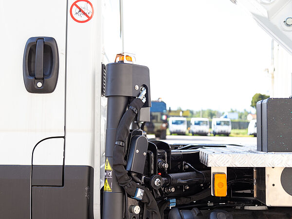 Seitenansicht der KLUBB PNT200 mit technischer Ausstattung hinter der Fahrerkabine – inklusive Warnhinweis für sicheren Betrieb im Straßenverkehr