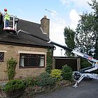 Anhänger Hubsteiger DINO 120T im Einsatz bei der Instandhaltung eines Häuserdaches